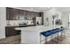 Modern kitchen features stainless appliances, dark cabinets, quartz counters, and stylish seating at the large island at 2511 W Queen Creek Rd # 262, Chandler, AZ 85248