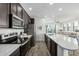 Stylish kitchen boasts stainless appliances, dark cabinets, quartz countertops, and seamless flow into the living area at 2511 W Queen Creek Rd # 262, Chandler, AZ 85248
