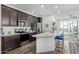 Modern kitchen has stainless appliances, dark cabinets, quartz counters, and island seating with views to the living area at 2511 W Queen Creek Rd # 262, Chandler, AZ 85248