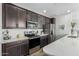 Modern kitchen features stainless steel appliances, dark cabinetry, and quartz countertops at 2511 W Queen Creek Rd # 262, Chandler, AZ 85248
