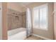Bright bathroom with a bathtub and a window with plantation shutters at 2753 E Kenwood St, Mesa, AZ 85213