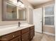 Well-lit bathroom featuring a vanity with wood cabinets, tile flooring and a large mirror at 2753 E Kenwood St, Mesa, AZ 85213