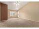 Spacious living room featuring neutral carpet, a ceiling fan and a large window at 2753 E Kenwood St, Mesa, AZ 85213