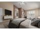 Cozy main bedroom featuring a stylish accent wall, vaulted ceiling, and ensuite bathroom at 2753 E Kenwood St, Mesa, AZ 85213