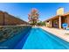 Backyard swimming pool featuring a rock water feature and mature shade tree at 2753 E Kenwood St, Mesa, AZ 85213