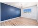 Empty bedroom featuring hardwood floors, a textured wall, and natural lighting at 3231 W Willow Ave, Phoenix, AZ 85029
