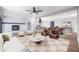 Open-concept living room with stylish furniture, fireplace, and an eat-in kitchen island at 3231 W Willow Ave, Phoenix, AZ 85029
