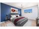 Bedroom with hardwood floors, a blue accent wall with artwork, and natural lighting at 3231 W Willow Ave, Phoenix, AZ 85029