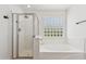 Modern bathroom featuring a glass shower and soaking tub with glass block window to let natural light in at 3370 E Flamingo Ct, Gilbert, AZ 85297