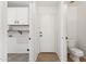 Combination laundry and half bath with white cabinetry and plenty of storage at 3370 E Flamingo Ct, Gilbert, AZ 85297