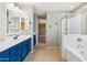 Stylish main bathroom with blue vanity, double sinks, separate shower, and a relaxing soaking tub at 3370 E Flamingo Ct, Gilbert, AZ 85297