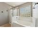 Inviting bathroom featuring a walk-in shower, soaking tub, and unique glass block window for natural light at 3370 E Flamingo Ct, Gilbert, AZ 85297
