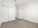 Cozy bedroom with carpet, double door closet, and adjacent door to another room at 37084 W Prado St, Maricopa, AZ 85138