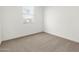 Clean bedroom features neutral walls, carpet flooring, and a window providing natural light at 37084 W Prado St, Maricopa, AZ 85138
