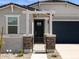 Welcoming front entrance with decorative stone accents, black metal gate, and covered porch at 37084 W Prado St, Maricopa, AZ 85138
