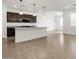Bright kitchen with island, dark cabinets, modern lighting, and an open concept floor plan at 37084 W Prado St, Maricopa, AZ 85138
