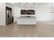 Open kitchen with island, stainless steel appliances, granite countertops, and dark cabinetry at 37084 W Prado St, Maricopa, AZ 85138