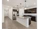 Spacious kitchen featuring an island, stainless steel refrigerator, granite countertops and dark brown cabinets at 37084 W Prado St, Maricopa, AZ 85138