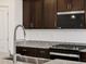 Close-up of kitchen features including granite countertops, stainless steel appliances, and dark wood cabinetry at 37084 W Prado St, Maricopa, AZ 85138