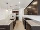 Open kitchen with island, stainless steel appliances, granite countertops, and dark cabinetry at 37084 W Prado St, Maricopa, AZ 85138