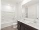 Bathroom featuring double sink vanity, a large mirror, and shower-tub combo at 37111 W Prado St, Maricopa, AZ 85138