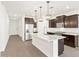 Open concept kitchen with stainless appliances, island, and modern pendant lighting at 37111 W Prado St, Maricopa, AZ 85138