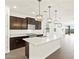 Open concept kitchen with stainless appliances, island, and modern pendant lighting at 37111 W Prado St, Maricopa, AZ 85138