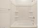Bathroom featuring a white tub and shower combination with built-in shelving at 37112 W Prado St, Maricopa, AZ 85138