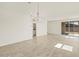 Open-concept living room with tile flooring, modern chandelier, and slider door to a fenced-in backyard at 37112 W Prado St, Maricopa, AZ 85138