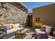 Cozy outdoor seating area with stone wall, comfortable furniture, and decorative pillows at 37300 N Tom Darlington Dr # D, Carefree, AZ 85377