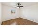 Bedroom featuring wood floors, ceiling fan, and window with plantation shutters at 4007 W Thunderbird Rd, Phoenix, AZ 85053