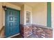 Inviting entryway featuring a teal front door, brick accents, and a stylish outdoor light fixture at 4007 W Thunderbird Rd, Phoenix, AZ 85053