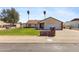 Charming single-story home featuring a lush green lawn, mature trees, and a welcoming two-car garage at 4007 W Thunderbird Rd, Phoenix, AZ 85053