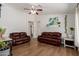 Bright living room featuring wood-look floors, ceiling fan and modern furnishings at 4232 N 112Th Ln, Phoenix, AZ 85037