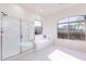 Bright bathroom featuring a glass shower and soaking tub with natural light at 4356 E Carriage Way, Gilbert, AZ 85297