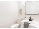 Clean, modern powder room with minimalist decor, black hardware, and a white vanity at 4356 E Carriage Way, Gilbert, AZ 85297