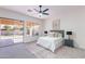 Bright bedroom with neutral colors, a ceiling fan, and a sliding glass door to the patio at 4356 E Carriage Way, Gilbert, AZ 85297