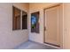 Front entryway featuring a paneled front door, side windows, and neutral-colored stucco walls at 4356 E Carriage Way, Gilbert, AZ 85297