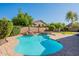 Sparkling backyard pool with rock features, spa, and mature trees, creating a private retreat at 4356 E Carriage Way, Gilbert, AZ 85297