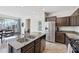 Bright kitchen with an island sink, stainless steel appliances, and an open layout leading to the dining area at 4646 E Maplewood St, Gilbert, AZ 85297