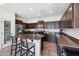 Beautiful kitchen with dark cabinetry, granite countertops, a large island with seating, and stainless steel appliances at 4646 E Maplewood St, Gilbert, AZ 85297