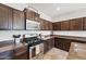 Modern kitchen with stainless steel appliances, dark cabinets, granite countertops, and ample counter space at 4646 E Maplewood St, Gilbert, AZ 85297