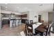 Open-concept kitchen and dining area, featuring dark wood cabinets, an island with bar stools, and a dining table at 4646 E Maplewood St, Gilbert, AZ 85297