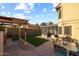 Backyard featuring an outdoor kitchen and screened porch with dining table and chairs on a patio at 4715 E Carmen St, Phoenix, AZ 85044