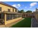 Expansive backyard featuring a screened-in porch, artificial turf, outdoor kitchen, and mature landscaping at 4715 E Carmen St, Phoenix, AZ 85044