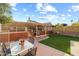 Backyard featuring outdoor kitchen with pergola, artificial turf, and a dining table with chairs at 4715 E Carmen St, Phoenix, AZ 85044