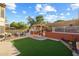 Inviting backyard featuring a pergola-covered outdoor kitchen, artificial turf, and a seating area at 4715 E Carmen St, Phoenix, AZ 85044