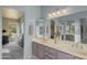 Bathroom featuring double sink vanity, decorative mirrors, and an open entry to the bedroom at 4715 E Carmen St, Phoenix, AZ 85044