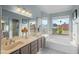 Bright bathroom with a large garden tub, double sink vanity, and a large window with scenic views at 4715 E Carmen St, Phoenix, AZ 85044