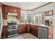 Updated kitchen with cherry wood cabinets, stainless steel appliances, tile backsplash, granite countertops, and natural light at 4715 E Carmen St, Phoenix, AZ 85044